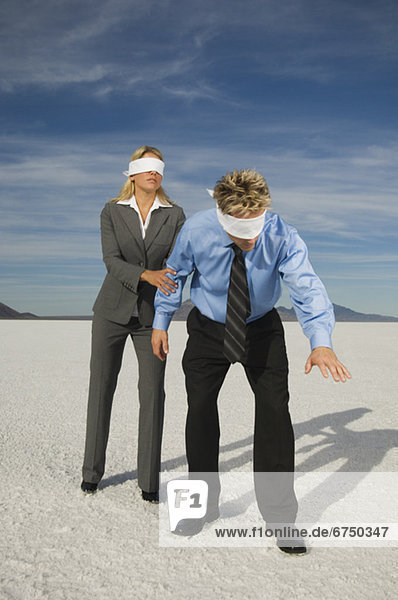 Blindfolded businesspeople on salt flats  Salt Flats  Utah  United States