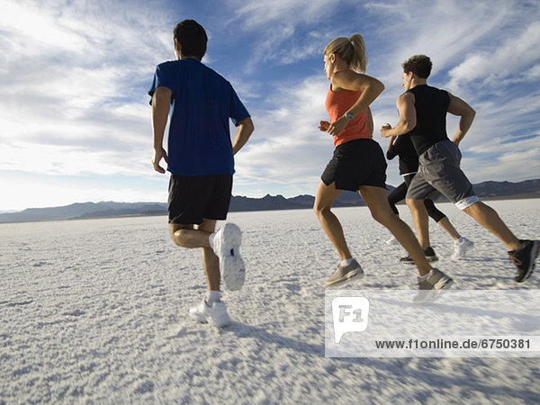 Group of people running on salt flats  Utah  United States