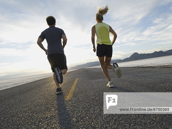 Couple running on road  Utah  United States