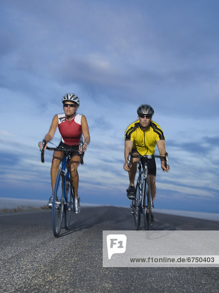Couple cycling on road  Utah  United States