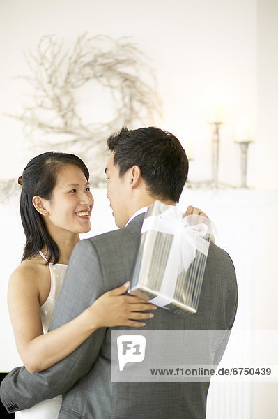 Couple Hugging  Woman holding Gift