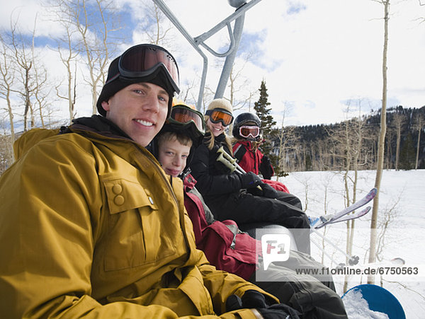 Family sitting on ski lift chair