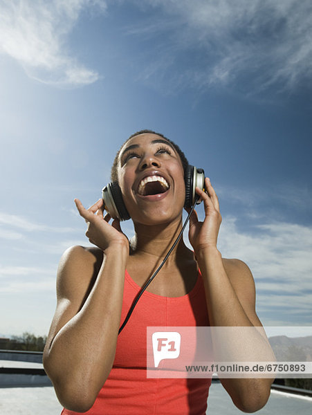 African woman listening to headphones
