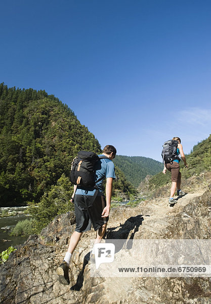 Hikers walking on riverside trail