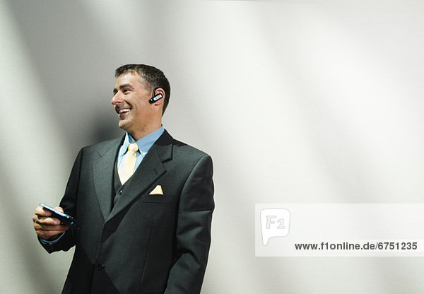 Businessman using cell phone and hands-free device