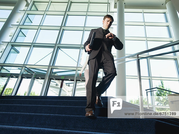 Businessman descending office building stairs