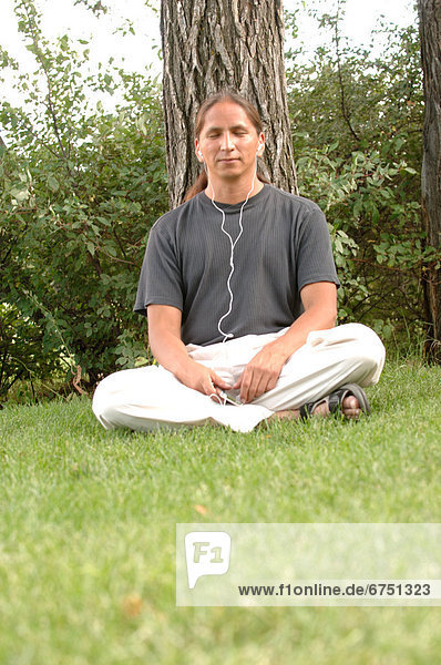 sitzend Mann zuhören Spiel MP3-Player MP3 Spieler MP3 Player MP3-Spieler Gras