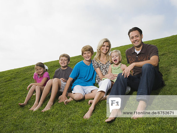 Familie sitzt im Gras