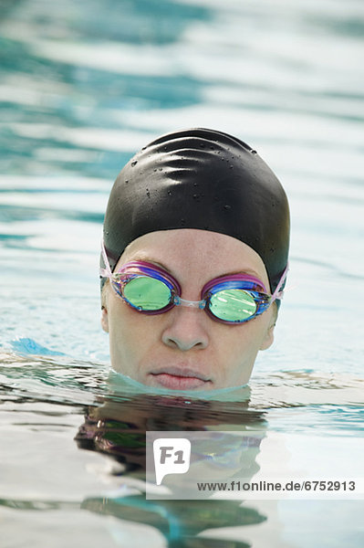 Woman wearing bathing cap and swimming goggles