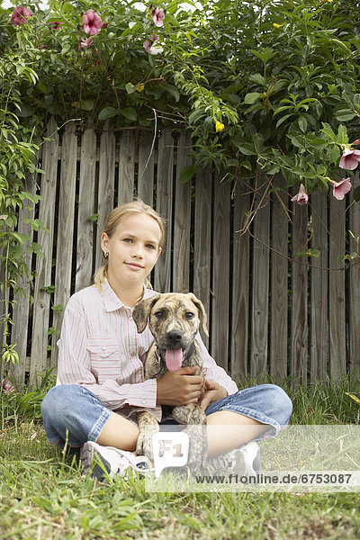 Young Girl Sitting on Lawn with Dog