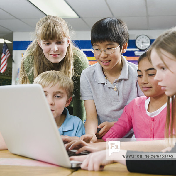 Elementary students looking at laptop