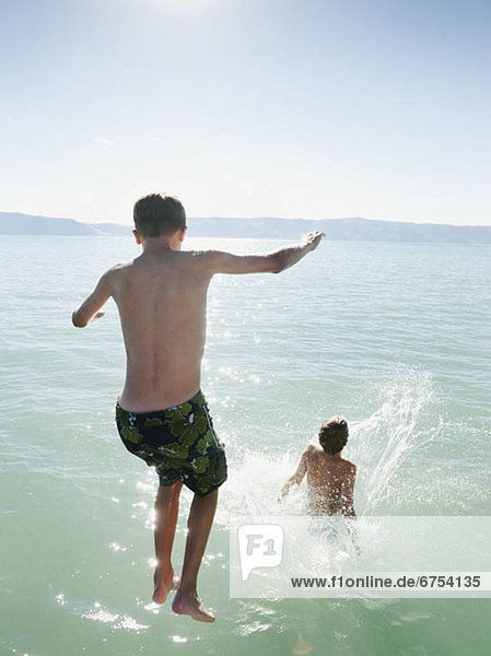 Boys (10-11 12-13) jumping into lake