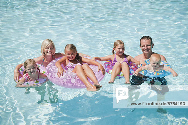 Family with four kids (12-18months  4-5 6-7 8-9) on swimming pool