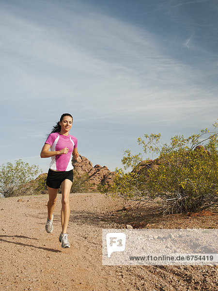 USA  Arizona  Phoenix  Young woman jogging on desert
