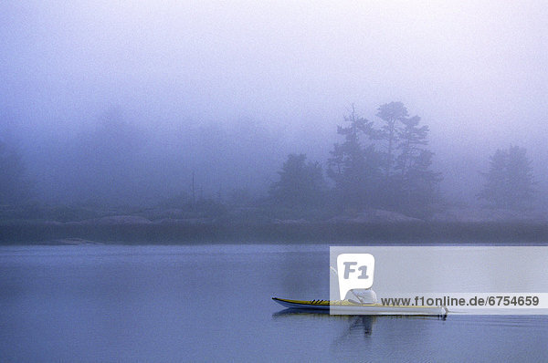 Kayaker in morning Fog  Georgian Bay Ontario.