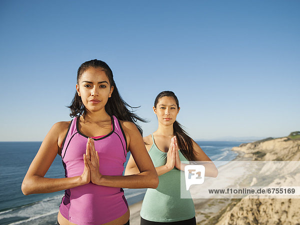 USA  California  San Diego  Two women practicing yoga on beach