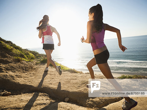 USA  California  San Diego  Two women jogging along sea coast