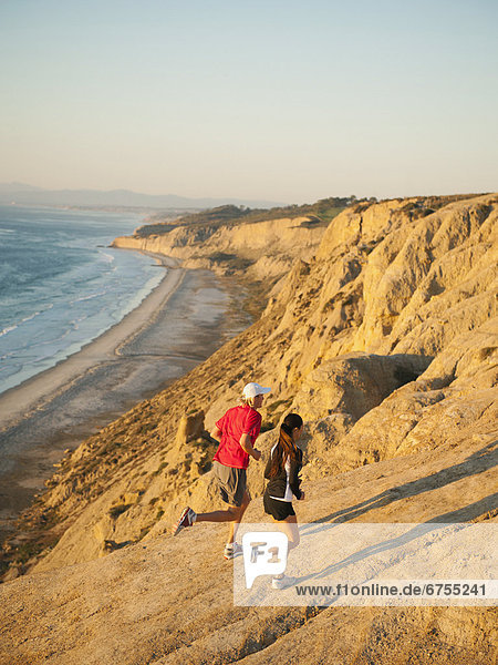 USA  California  San Diego  Man and woman jogging along sea coast