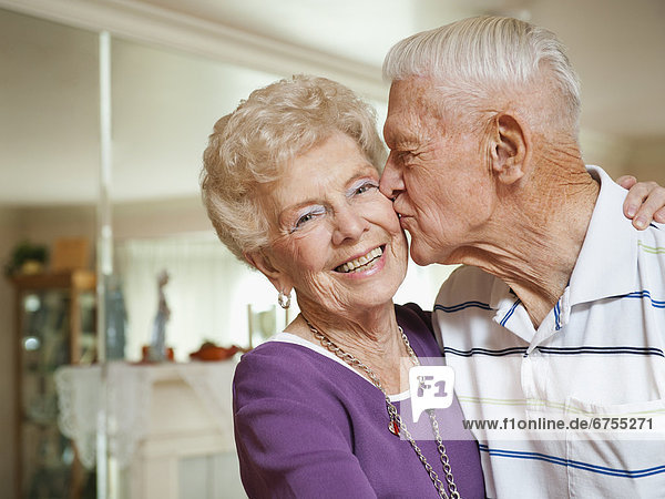 Senior man kissing woman