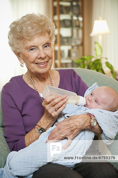Portrait of senior woman giving milk to grandson (2-5 months)