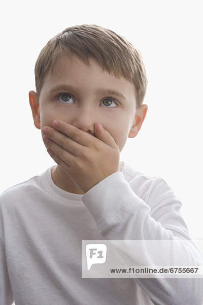 Boy covering mouth with hand