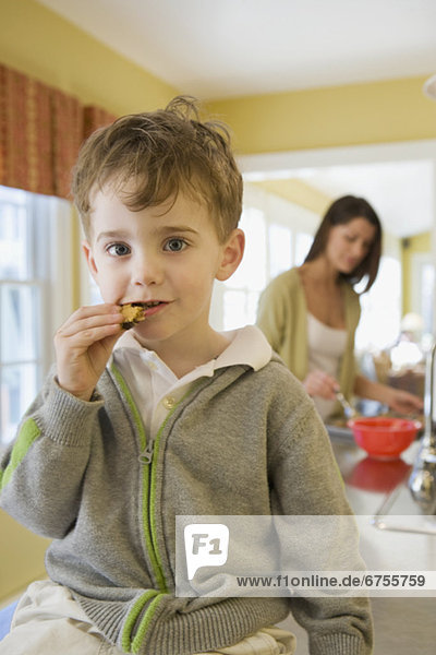 Junge - Person Küche essen essend isst Keks Tresen