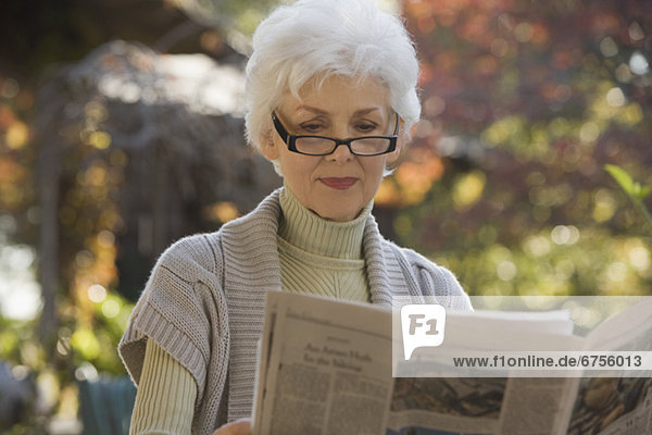 Außenaufnahme  Senior  Senioren  Frau  Zeitung  freie Natur  vorlesen