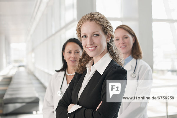 USA  Virginia  Virginia Beach  portrait of businesswoman with doctors in background