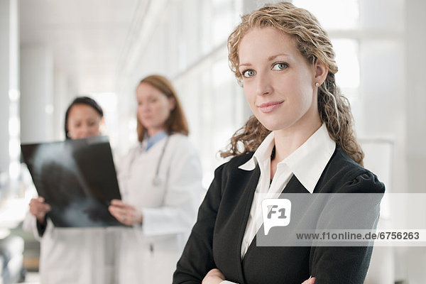 USA  Virginia  Virginia Beach  portrait of businesswoman with doctors in background