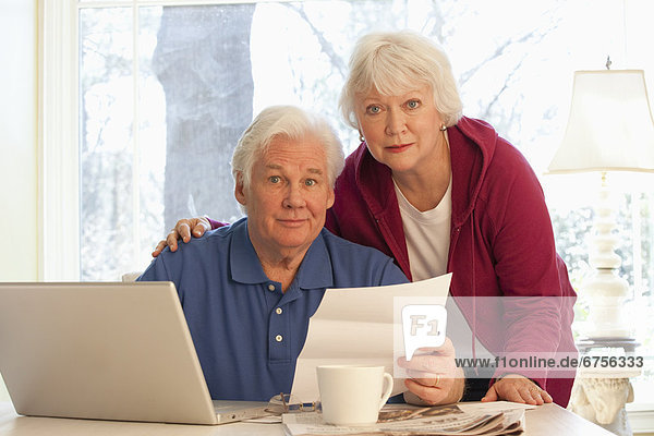 USA  Virginia  Richmond  portrait of senior couple paying bills with laptop