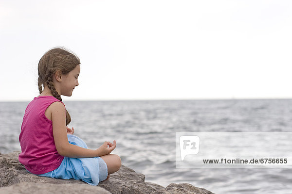Artist's Choice: Little Girl Meditating Sitting on a Rock by Lake Ontario  Toronto  Ontario