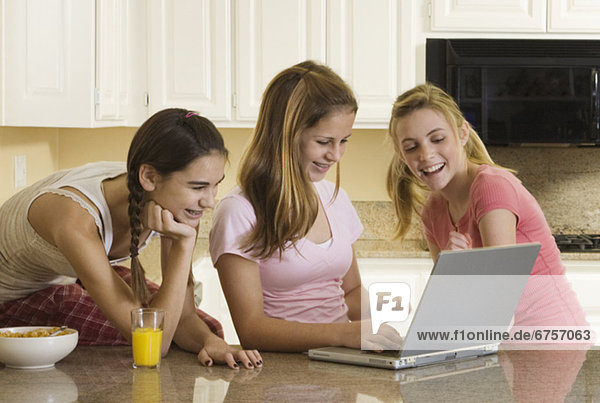 Teenaged girls looking at laptop