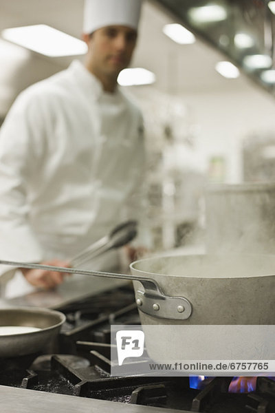 Chef and steaming pot on stove