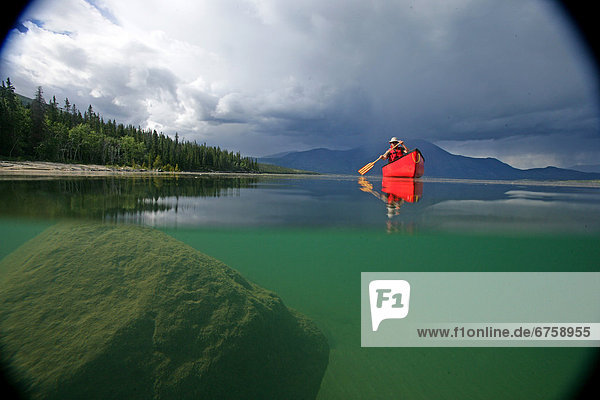 Vignetted Underwater Image of a Man Canoeing on Kusawa Lake  Yukon