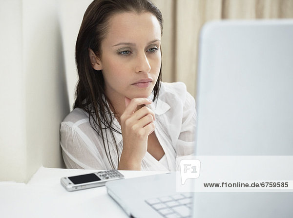 Woman deep in thought while looking at laptop