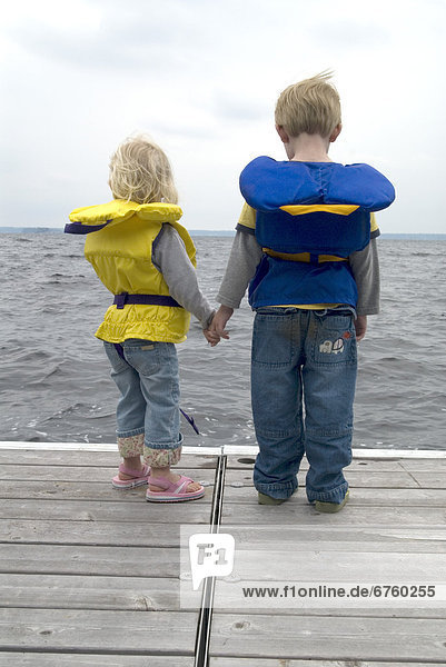Brother and Sister Holding Hands on a Dock in Life Jackets  Lake Muskoka  Bracebridge  Ontario