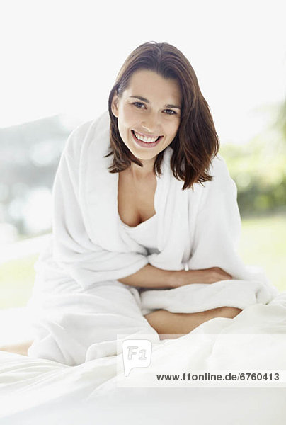 Smiling brunette woman wearing a bathrobe