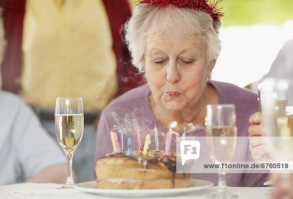 Senior  Senioren  Frau  Geburtstag  Kuchen  Kerze  Kerzen ausblasen