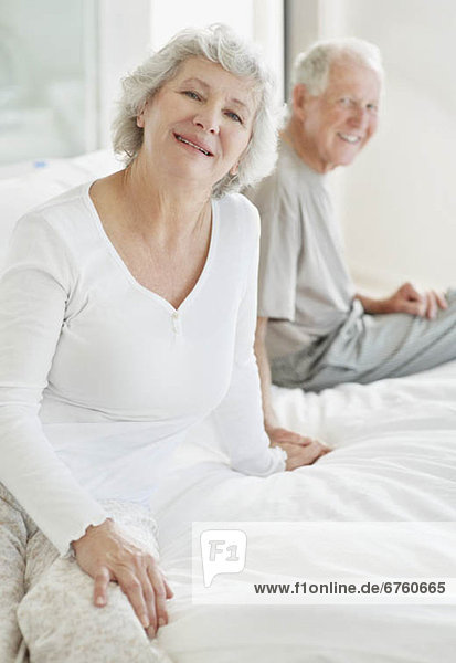 Relaxed senior couple sitting on bed