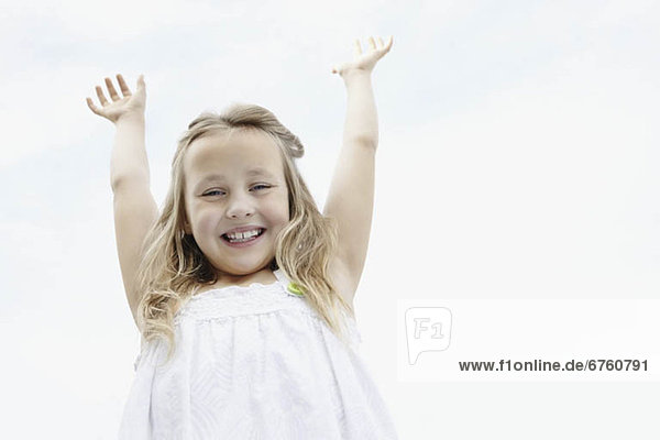 Young girl with her arms raised
