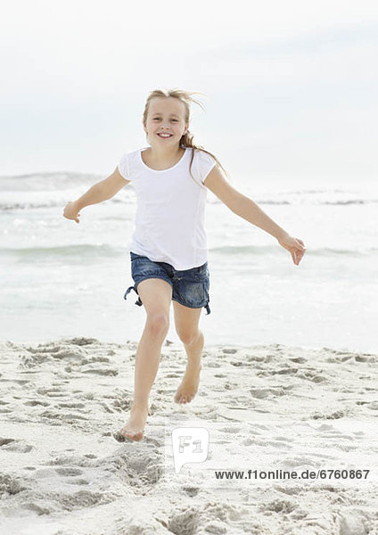 Portrait of girl (10-11) running on beach