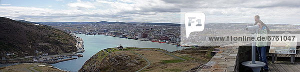 Couple using Public Binoculars on Signal Hill  over looking St. Johns Harbour  St. Johns  Newfoundland