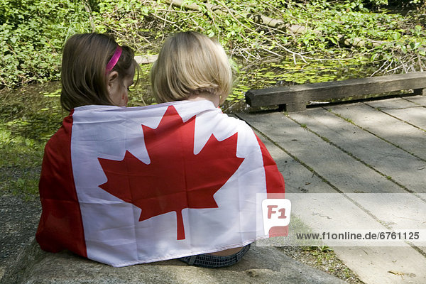 Little Girls Sitting with a Canadian Flag around them  Vancouver  British Columbia