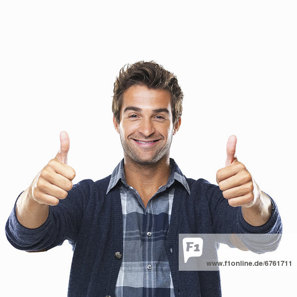 Studio shot of young man with two thumbs up