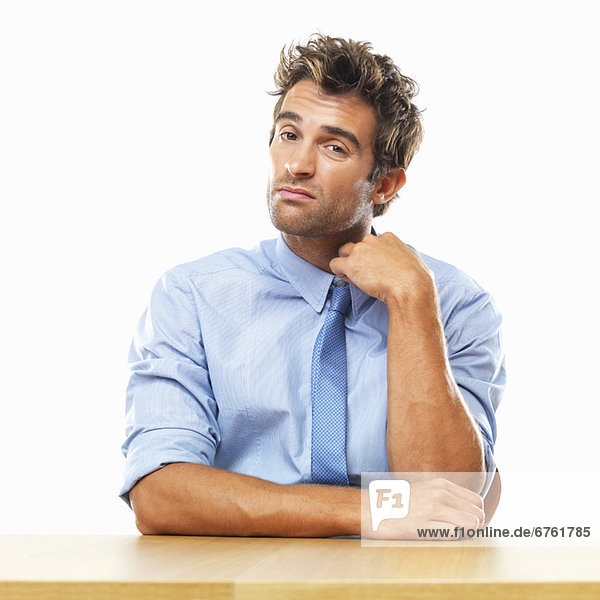 Business man sitting at table and touching collar