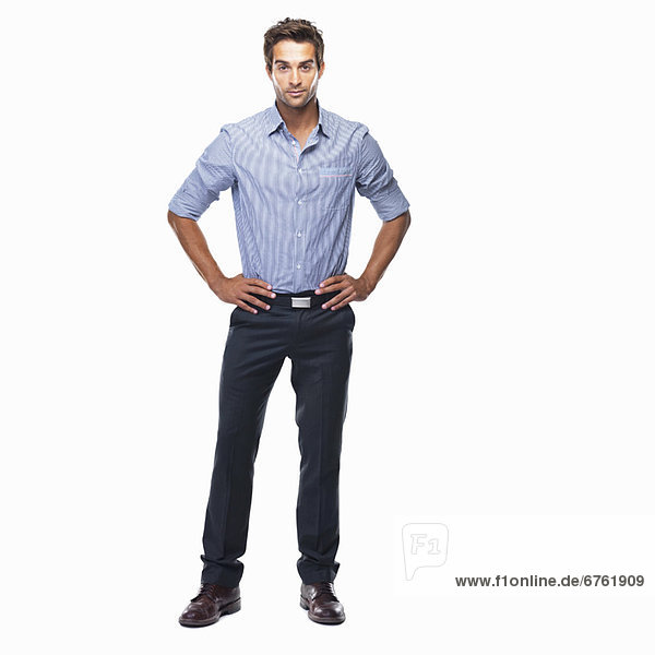 Studio shot of attractive business man standing with hands on hips