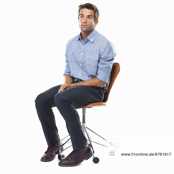 Studio shot of pensive business man sitting on chair