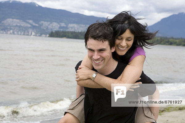 Couple on Kitsilano Beach with Downtown Vancouver in background  British Columbia