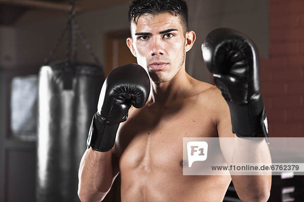 USA  Seattle  Portrait of young man in gym wearing boxing gloves