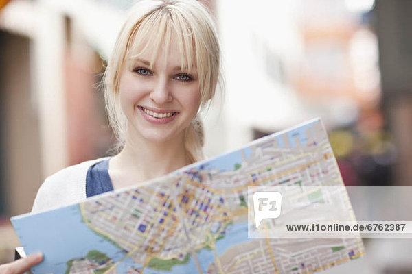 USA  Seattle  Smiling young woman holding map